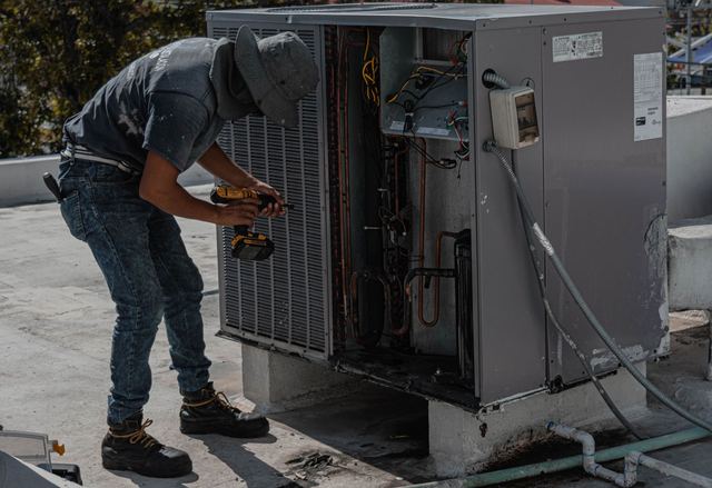 Un técnico reparando un aire acondicionado